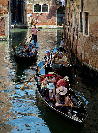 A back street with lots of light and shadow and 2 smiling gondoliers