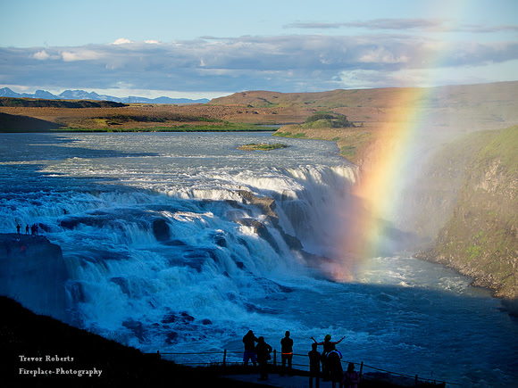 Gullfoss on a sunny day with a rainbow rising in the spray